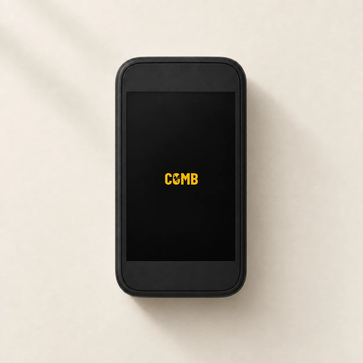 Illustrative top-down view of Comb Flex, a black portrait touchscreen reader with a small yellow Comb logo, on an ivory surface.